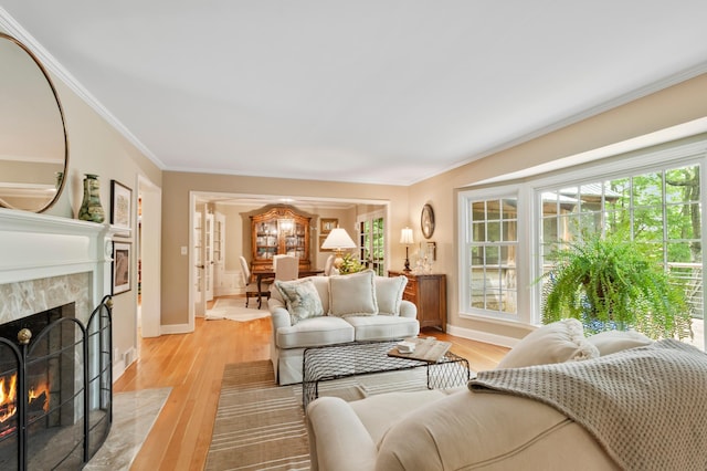 living room featuring light hardwood / wood-style flooring, crown molding, and a premium fireplace