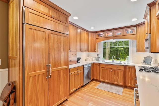 kitchen with stainless steel appliances, light hardwood / wood-style flooring, and sink