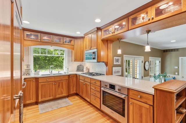 kitchen with kitchen peninsula, stainless steel appliances, french doors, hanging light fixtures, and sink