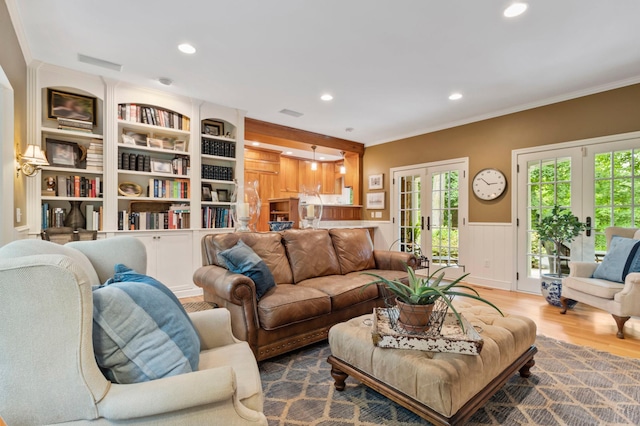 living room with ornamental molding, wood-type flooring, built in features, and french doors