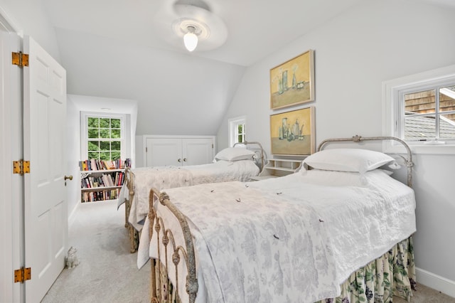 bedroom featuring lofted ceiling, light colored carpet, and ceiling fan