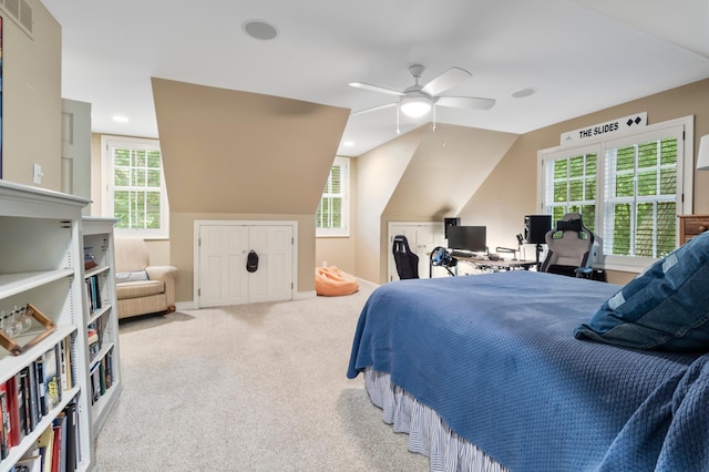 carpeted bedroom with ceiling fan, vaulted ceiling, and multiple windows