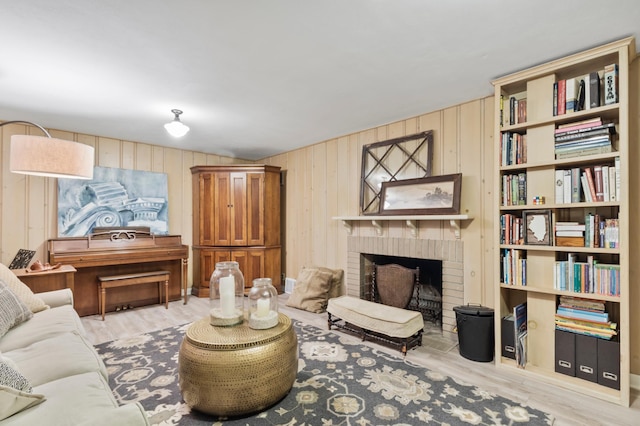 sitting room featuring a brick fireplace and light wood-type flooring