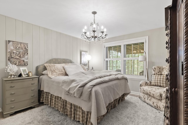 bedroom featuring wood walls and an inviting chandelier