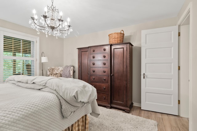 bedroom featuring light hardwood / wood-style floors and a chandelier