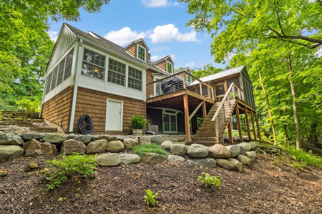 rear view of property with a wooden deck and a sunroom