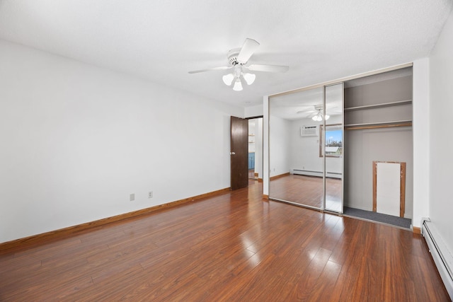 unfurnished bedroom featuring ceiling fan, a baseboard heating unit, a closet, and hardwood / wood-style floors