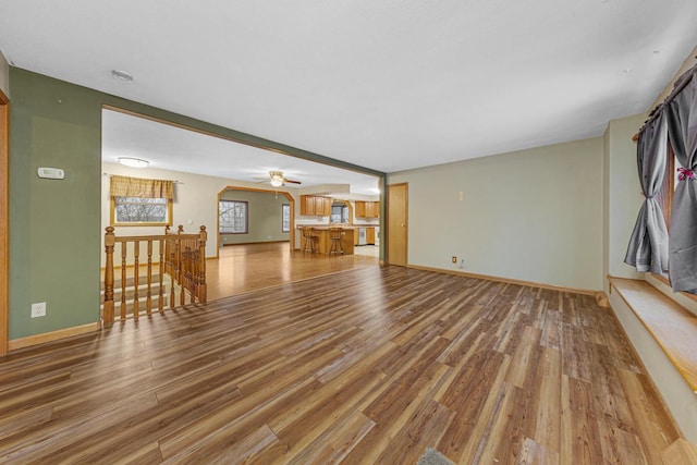 unfurnished living room with ceiling fan and wood-type flooring