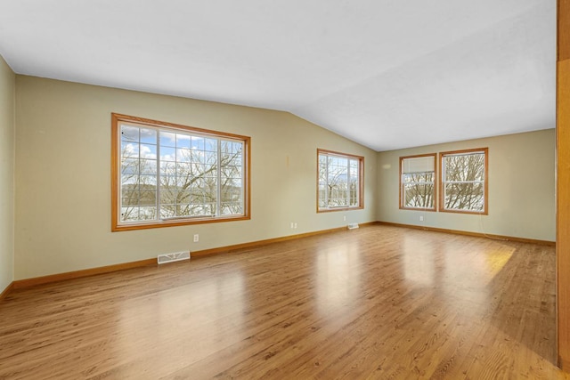 unfurnished room with light wood-type flooring and lofted ceiling