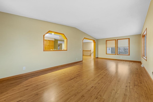 unfurnished living room with light wood-type flooring and vaulted ceiling