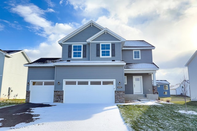 craftsman-style home featuring a garage and a yard