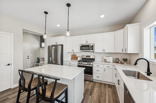 kitchen featuring hanging light fixtures, white cabinets, appliances with stainless steel finishes, and sink