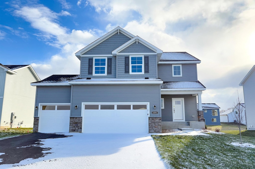 craftsman-style home featuring a garage and a yard