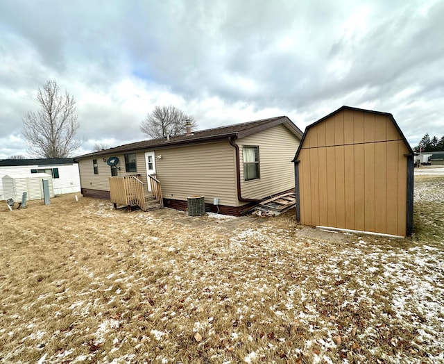 rear view of property featuring a storage shed