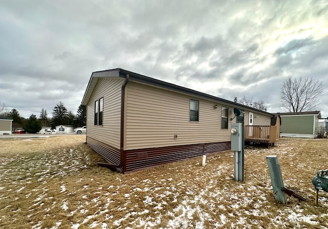 view of snow covered exterior with a deck