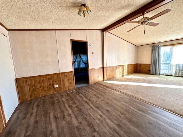 spare room featuring ceiling fan, a textured ceiling, dark hardwood / wood-style flooring, and vaulted ceiling with beams