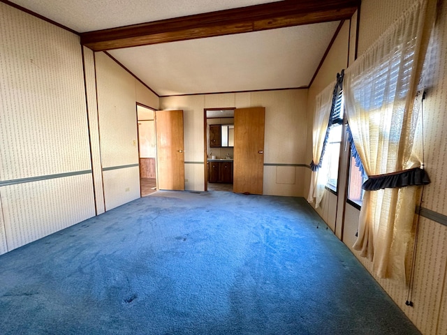 carpeted spare room featuring vaulted ceiling, ornamental molding, and a textured ceiling