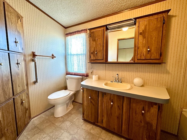 bathroom featuring a textured ceiling, toilet, crown molding, and vanity