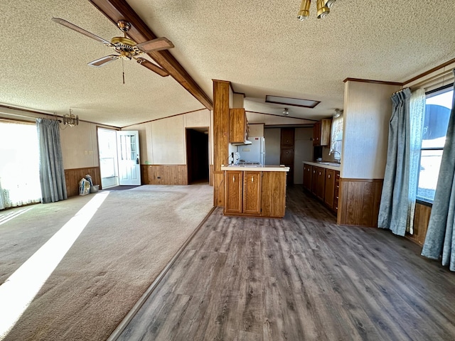 kitchen with a textured ceiling, white refrigerator, sink, dark hardwood / wood-style floors, and beam ceiling