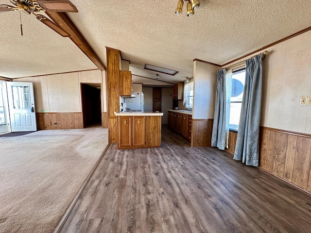 kitchen featuring a textured ceiling, white fridge, sink, lofted ceiling with beams, and ceiling fan