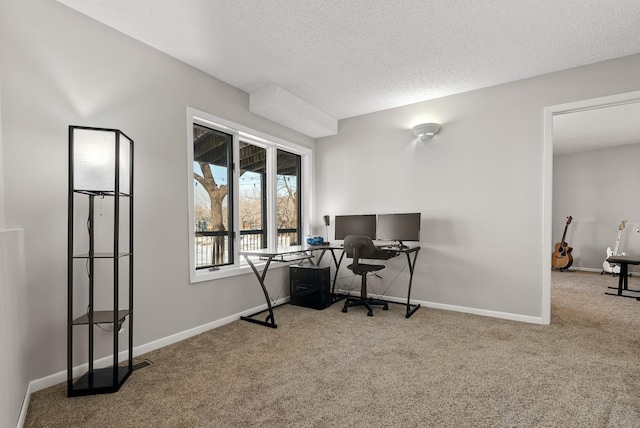 home office featuring a textured ceiling, baseboards, and carpet floors