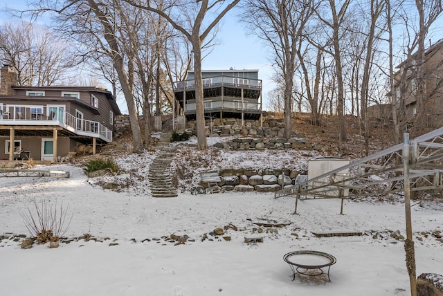 snow covered back of property featuring a deck and a chimney