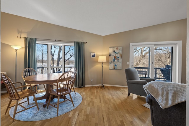 dining area with lofted ceiling, plenty of natural light, light wood-style floors, and baseboards