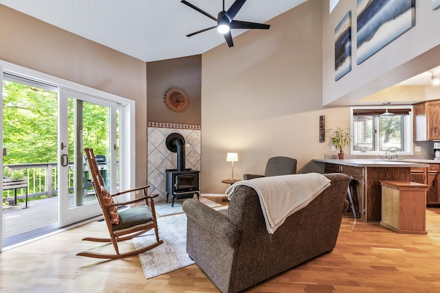 16164 Lakeside Ave SE, Prior Lake, MN 55372 - living area with light wood-type flooring, high vaulted ceiling, a wood stove, and ceiling fan