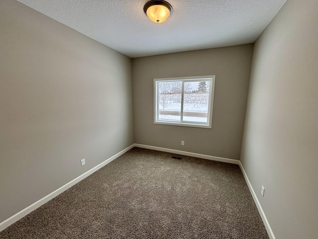 carpeted empty room with a textured ceiling