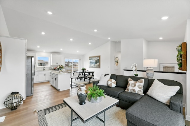 living room with light hardwood / wood-style floors and lofted ceiling