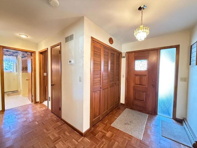 foyer featuring light parquet flooring, a wealth of natural light, and a baseboard heating unit