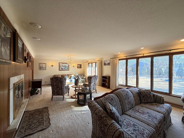 carpeted living room with a fireplace, a chandelier, and a textured ceiling