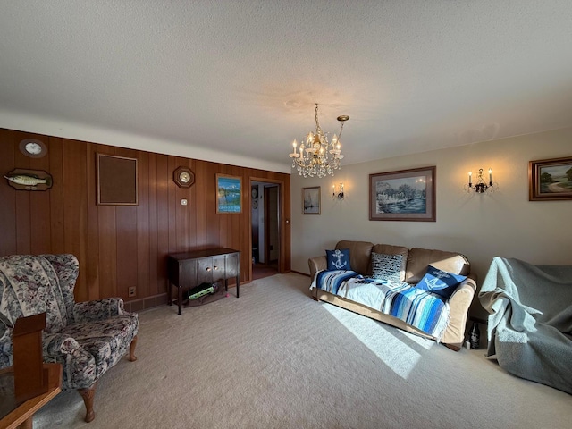 living room with wooden walls, carpet floors, a chandelier, and a textured ceiling