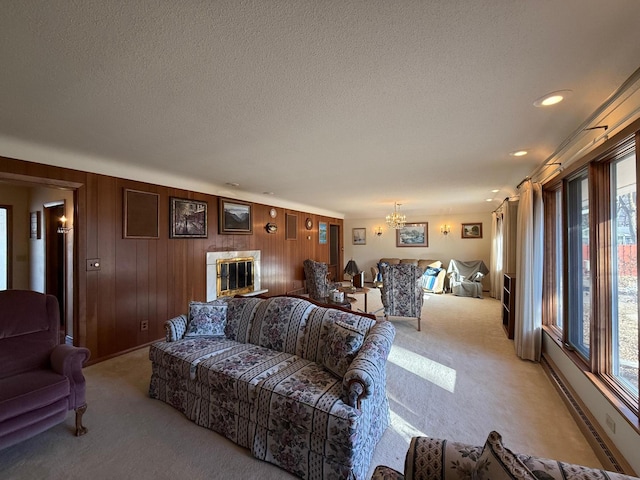 carpeted living room with wood walls, a textured ceiling, and a notable chandelier