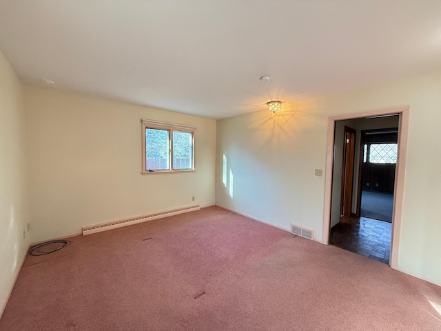 spare room featuring baseboard heating and dark carpet