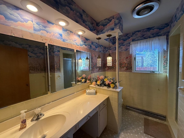 bathroom featuring tile patterned flooring, vanity, tile walls, and walk in shower