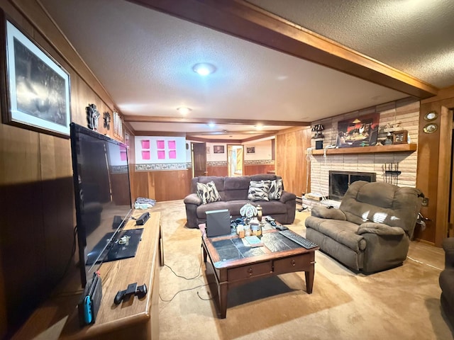 carpeted living room featuring beam ceiling, a fireplace, a textured ceiling, and wood walls