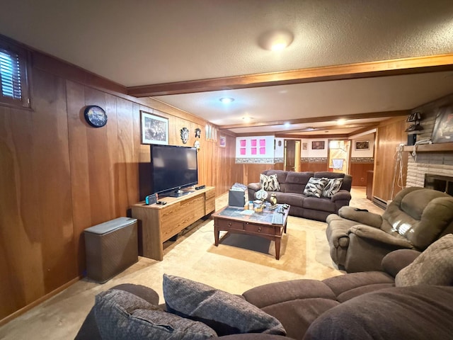 living room with beam ceiling, a fireplace, a textured ceiling, light carpet, and wood walls