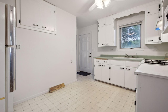 kitchen with ceiling fan, white cabinets, stainless steel fridge, and sink