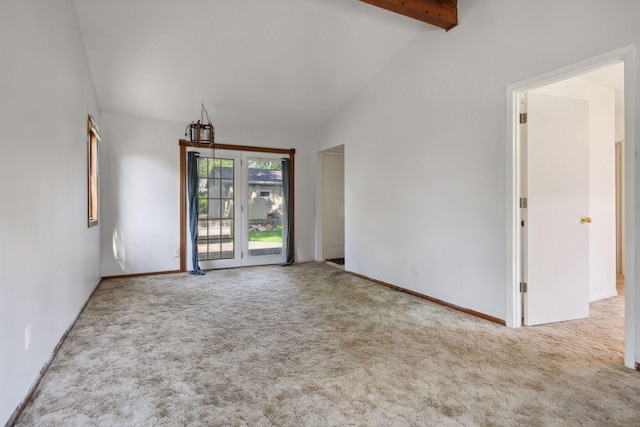 empty room featuring light carpet and lofted ceiling with beams