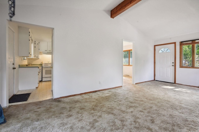 entryway featuring light carpet, beam ceiling, and high vaulted ceiling