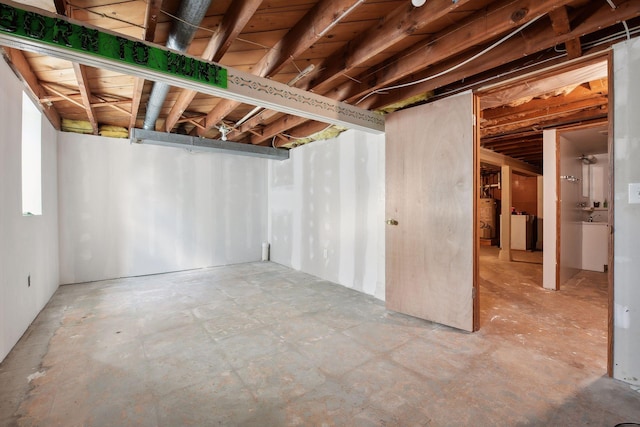 basement featuring water heater and washer / clothes dryer