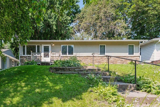 single story home featuring a front lawn and a wooden deck