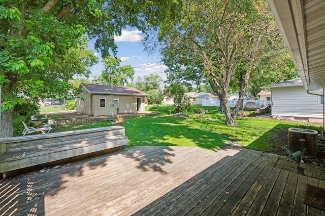 wooden terrace with central AC, a yard, and an outdoor structure