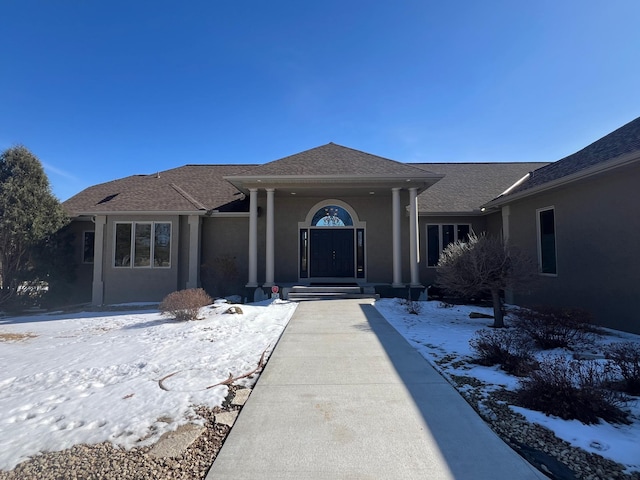 ranch-style house with roof with shingles and stucco siding