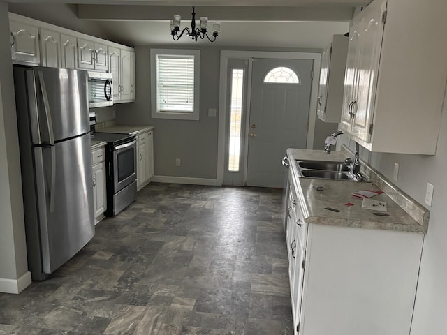 kitchen featuring white cabinets, a chandelier, sink, and stainless steel appliances