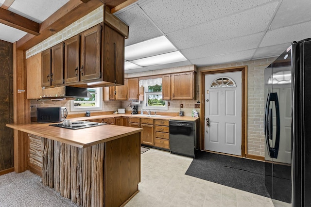 2021 Main St S, Pine City Twp, MN 55063 - kitchen featuring black appliances, a peninsula, backsplash, light flooring, and a paneled ceiling