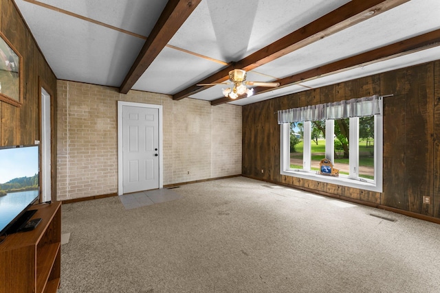 2021 Main St S, Pine City Twp, MN 55063 - unfurnished living room with carpet floors, ceiling fan, wooden walls, beamed ceiling, and brick wall
