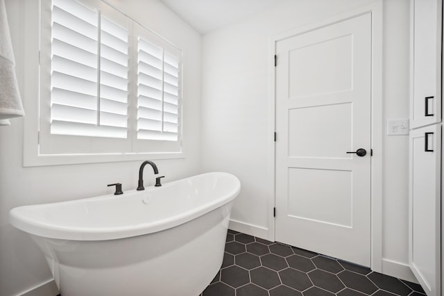 bathroom featuring a tub to relax in and tile patterned flooring