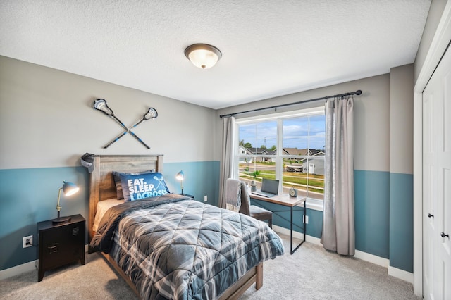 bedroom with light carpet, a closet, and a textured ceiling